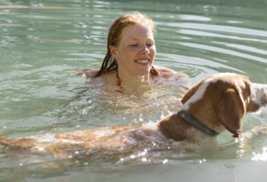 Tutora com seu cão na água - Foto: Freepik