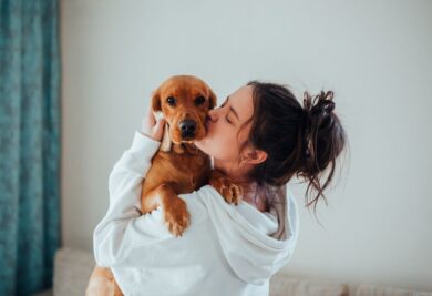 Tutora com seu cachorro no colo - Foto: Canva